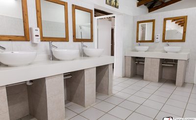 Ablution block interior with bowl basins and wooden-framed mirrors