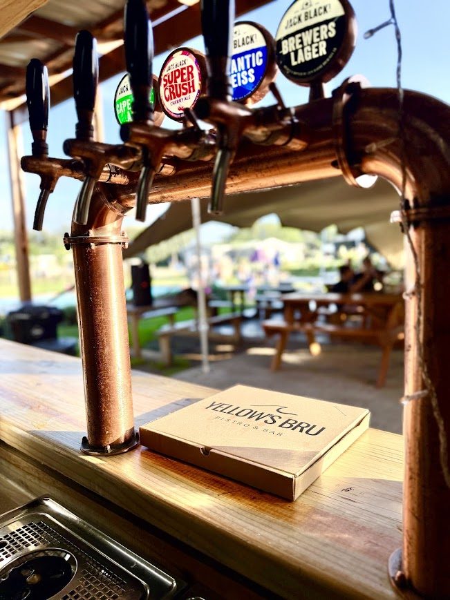 Copper craft beer taps and a Yellow's Bru pizza box