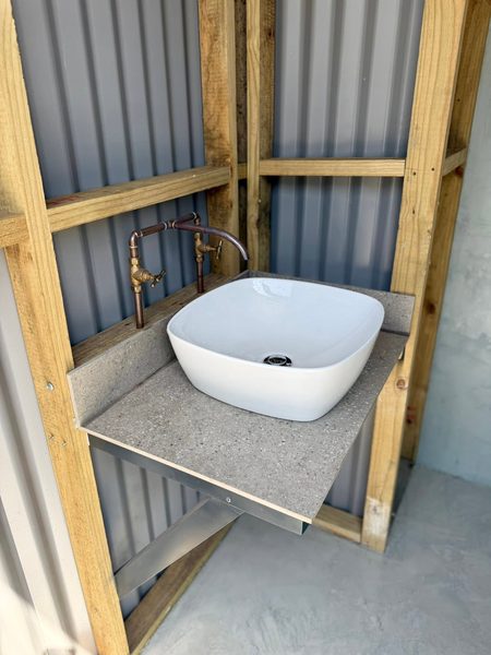 Basin with exposed copper fittings in the new mini ablution block